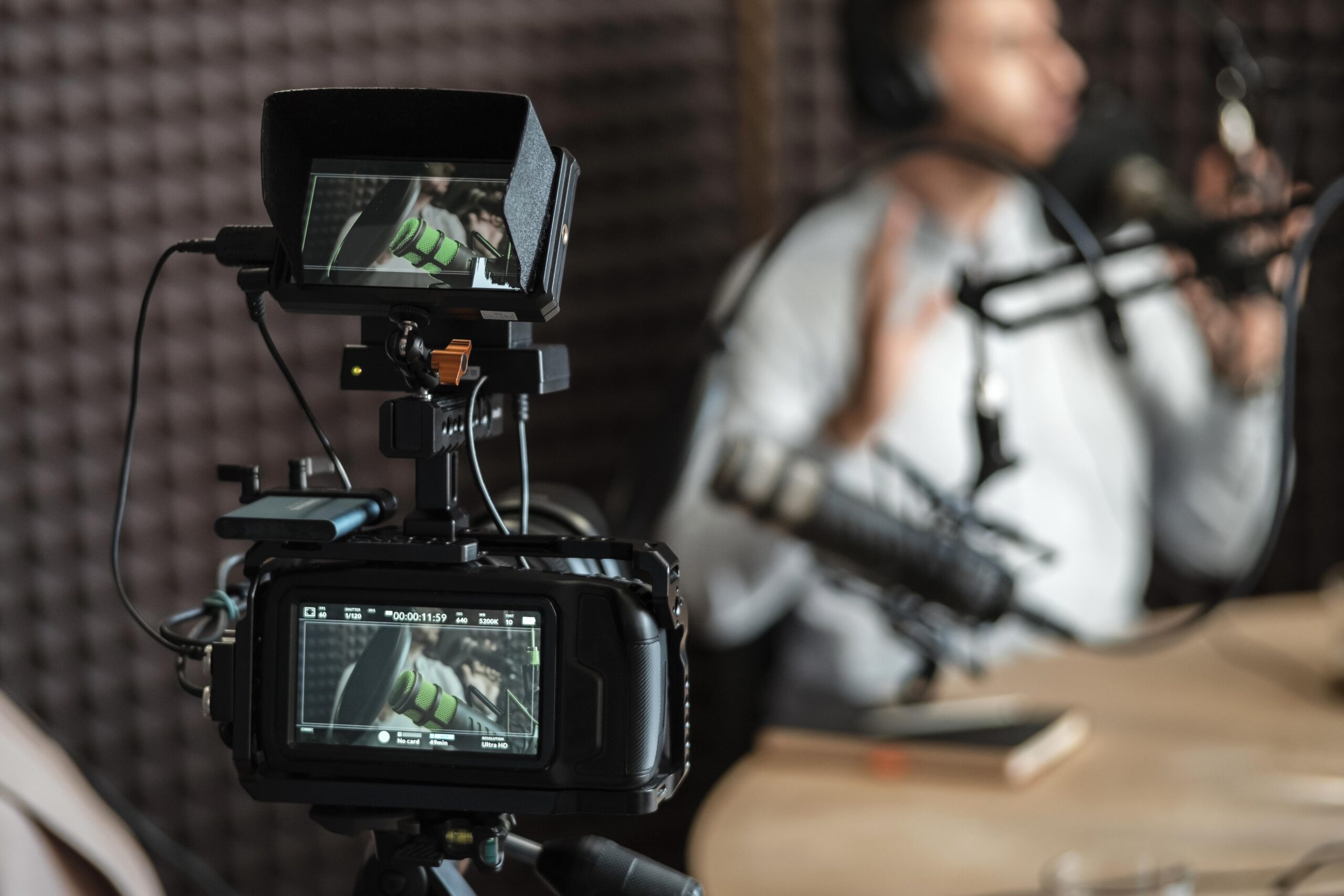 Man being filmed in studio by media communications team