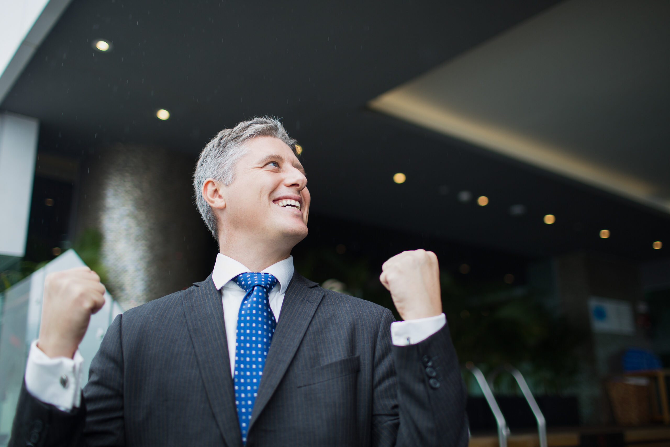 Happy middle aged businessman with winning gesture