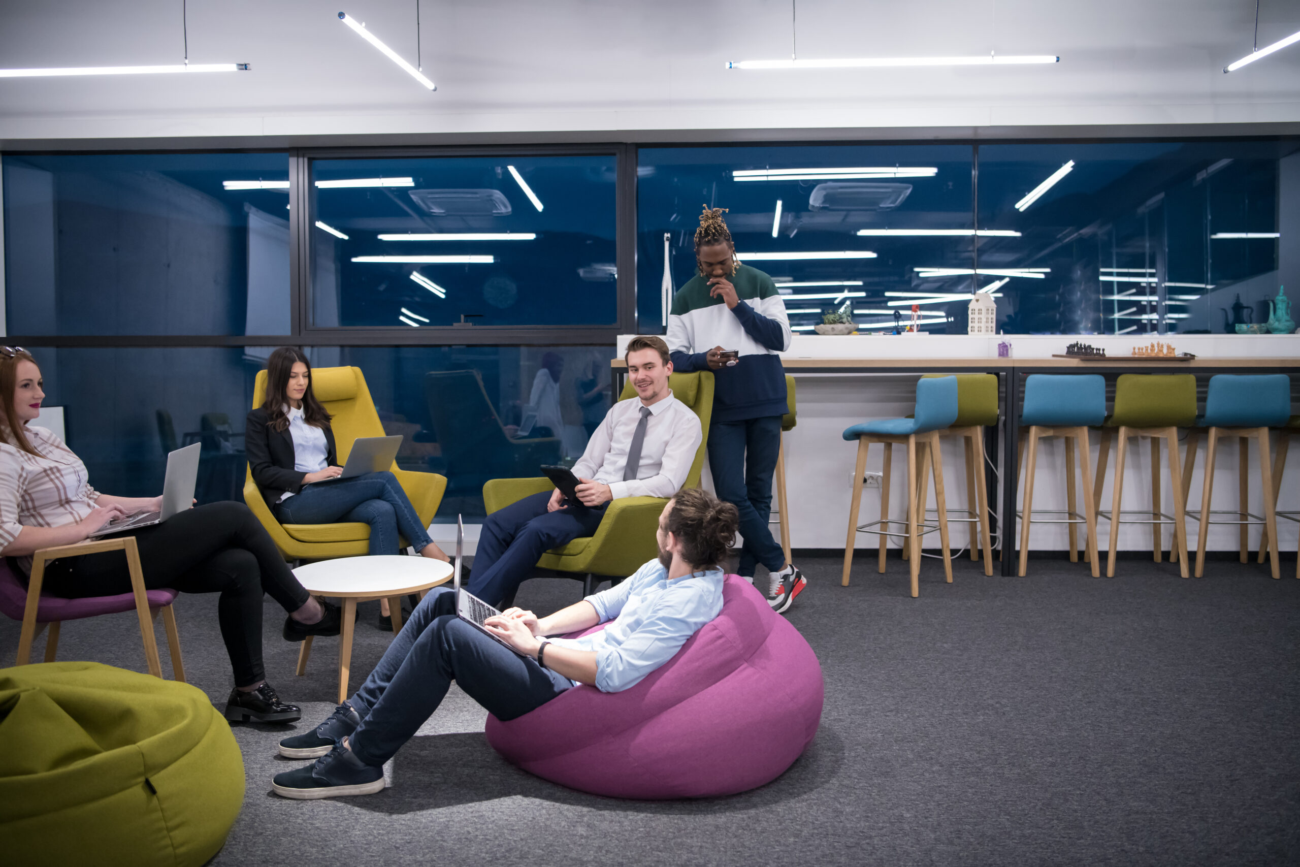 Employees sat together in flexible office area, with beanbags and comfortable chairs