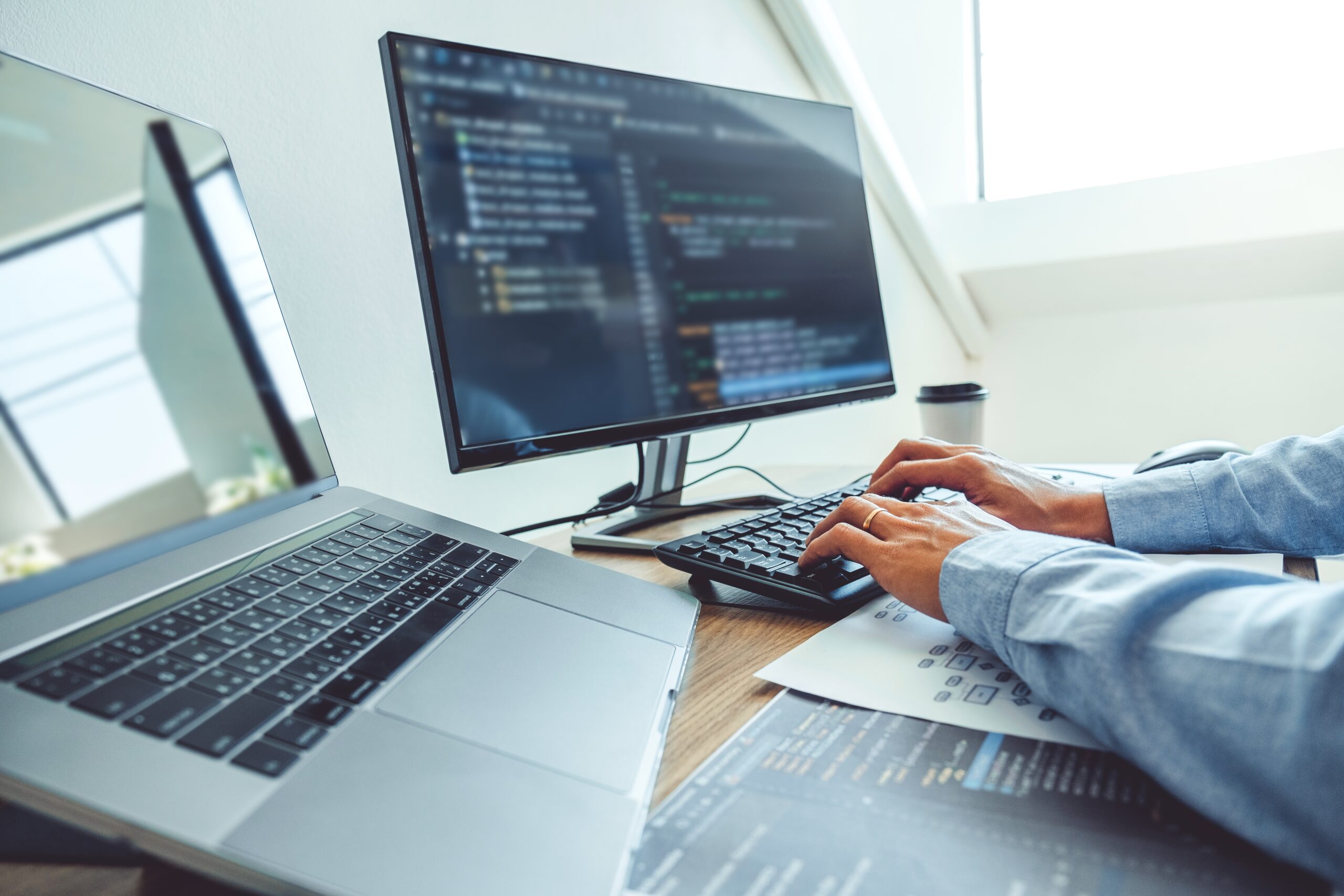 Programmer in the office using computer and laptop