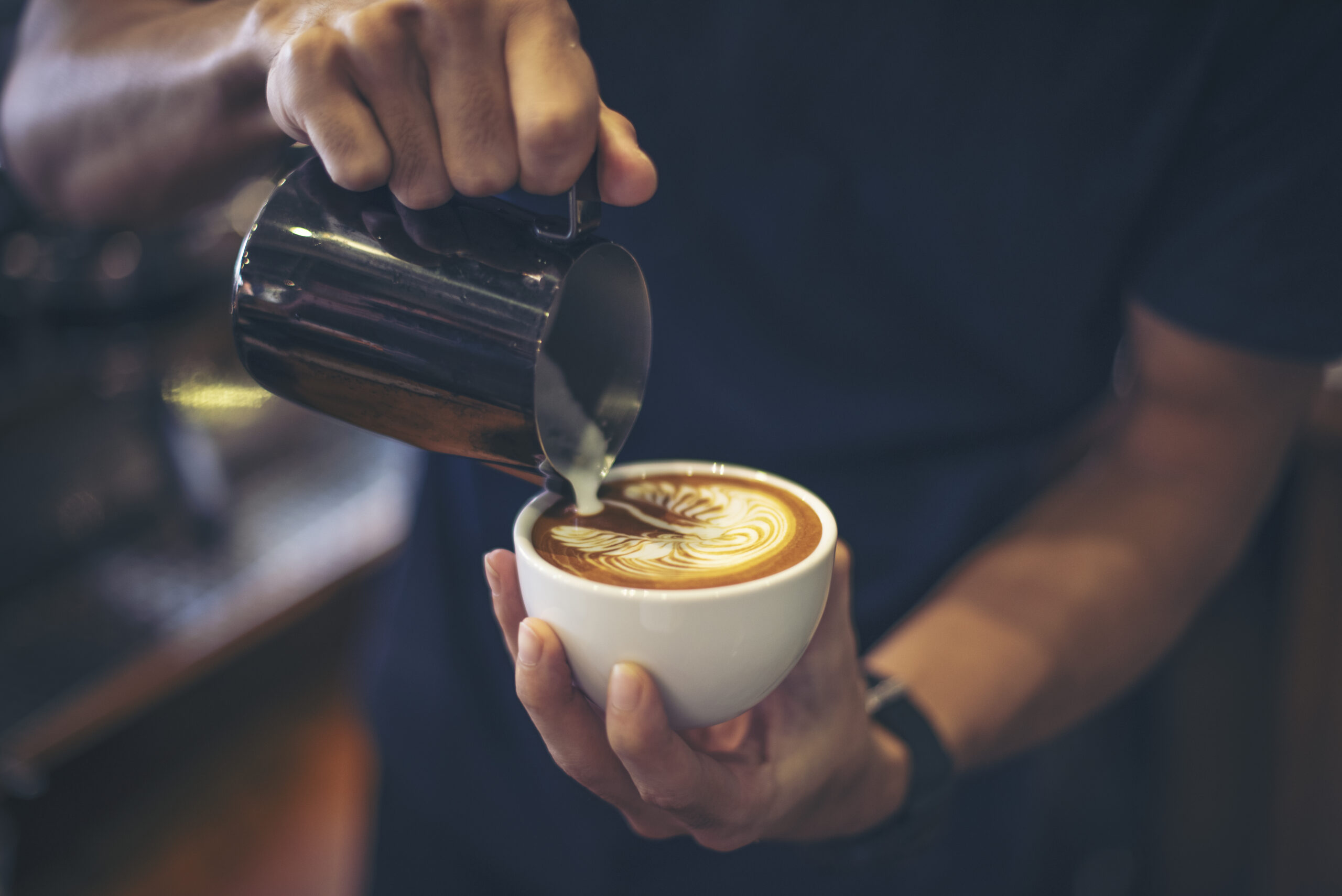 Close up of barista making a latte