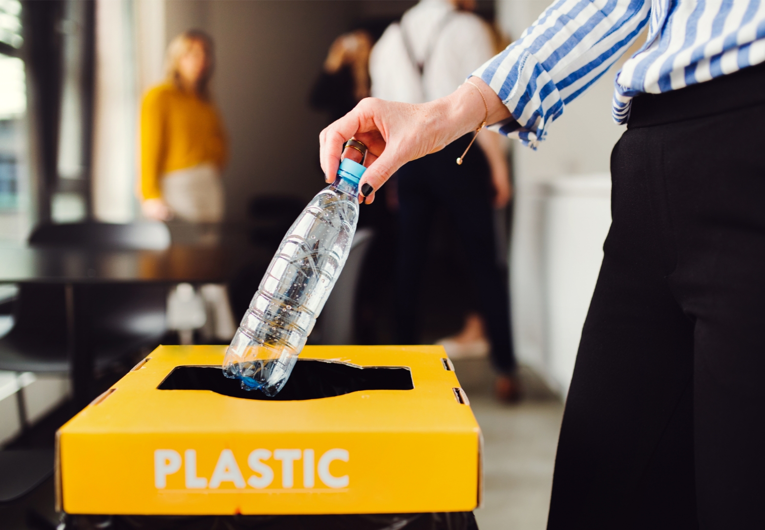 Office worker recycling water bottle